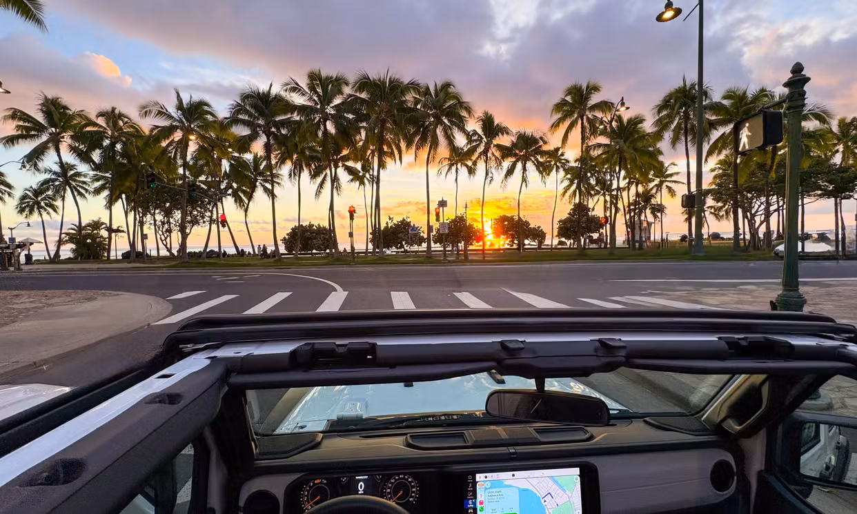 Open-air Jeep view on an Oahu road at sunset
